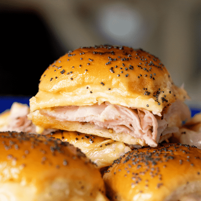 Ham and cheese slider topped with poppy seeds.