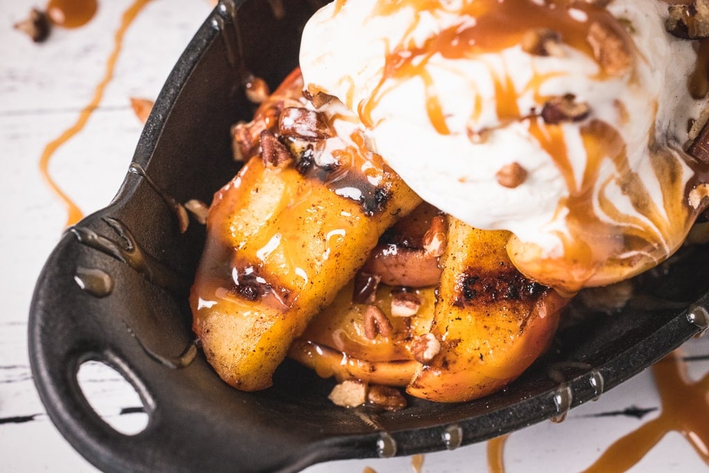 Cinnamon grilled apples topped with whipped cream and bourbon caramel sauce.