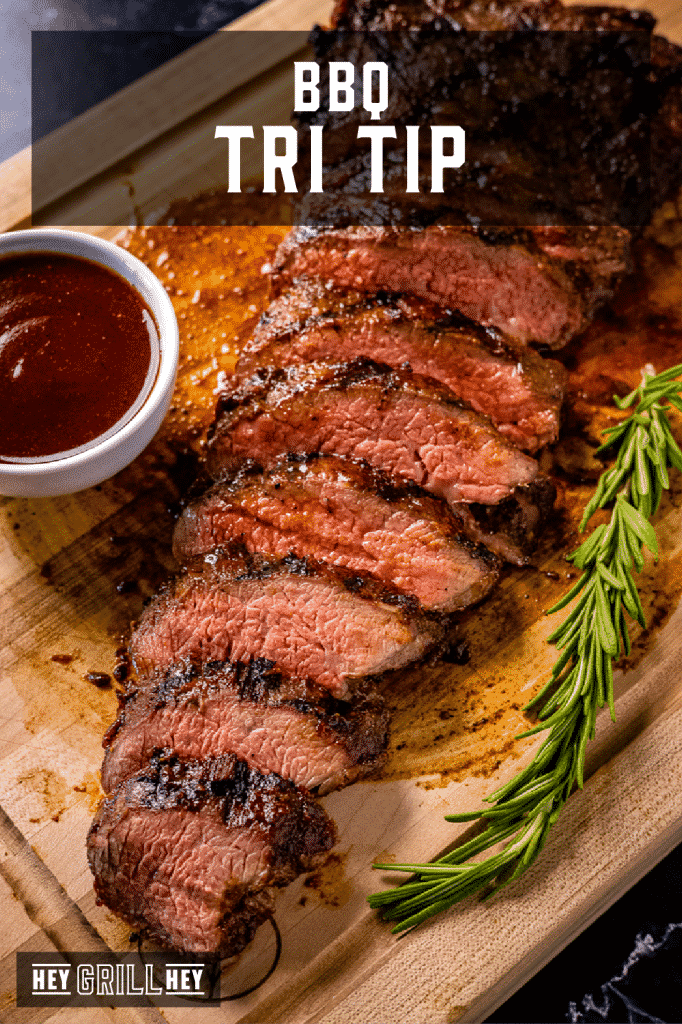 Sliced BBQ tri tip on a wooden cutting board with text overlay - BBQ Tri Tip.