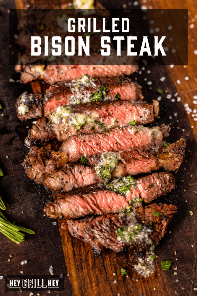 Sliced grilled bison steak topped with resting butter on a wooden cutting board with text overlay - Grilled Bison Steak.