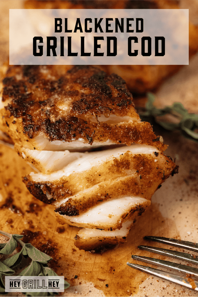 Flaked blackened grilled cod on a wooden cutting board with text overlay - Blackened Grilled Cod.
