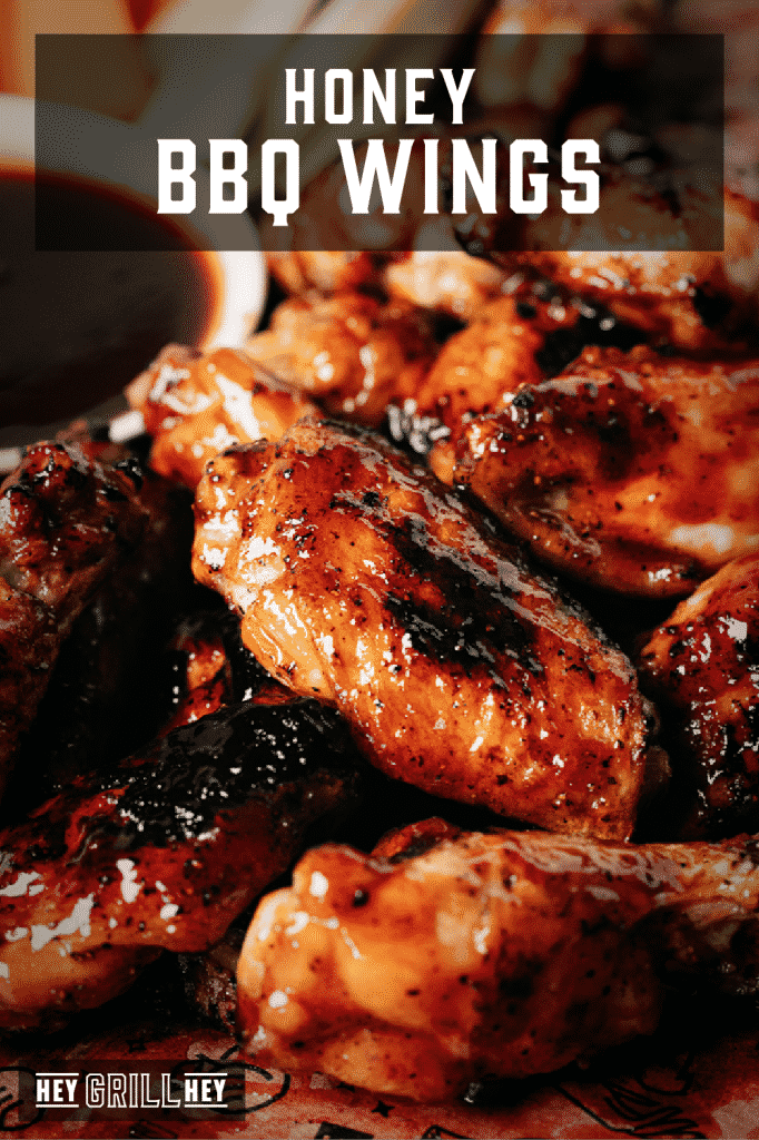 Grilled chicken wings covered in honey BBQ sauce with text overlay - Honey BBQ Wings.