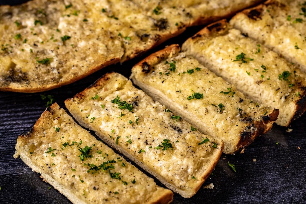 Sliced grilled garlic bread on a serving dish.