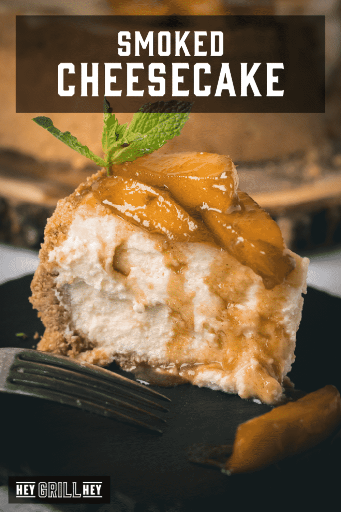 Slice of smoked cheesecake topped with brandied peaches and a sprig of mint with text overlay - Smoked Cheesecake.