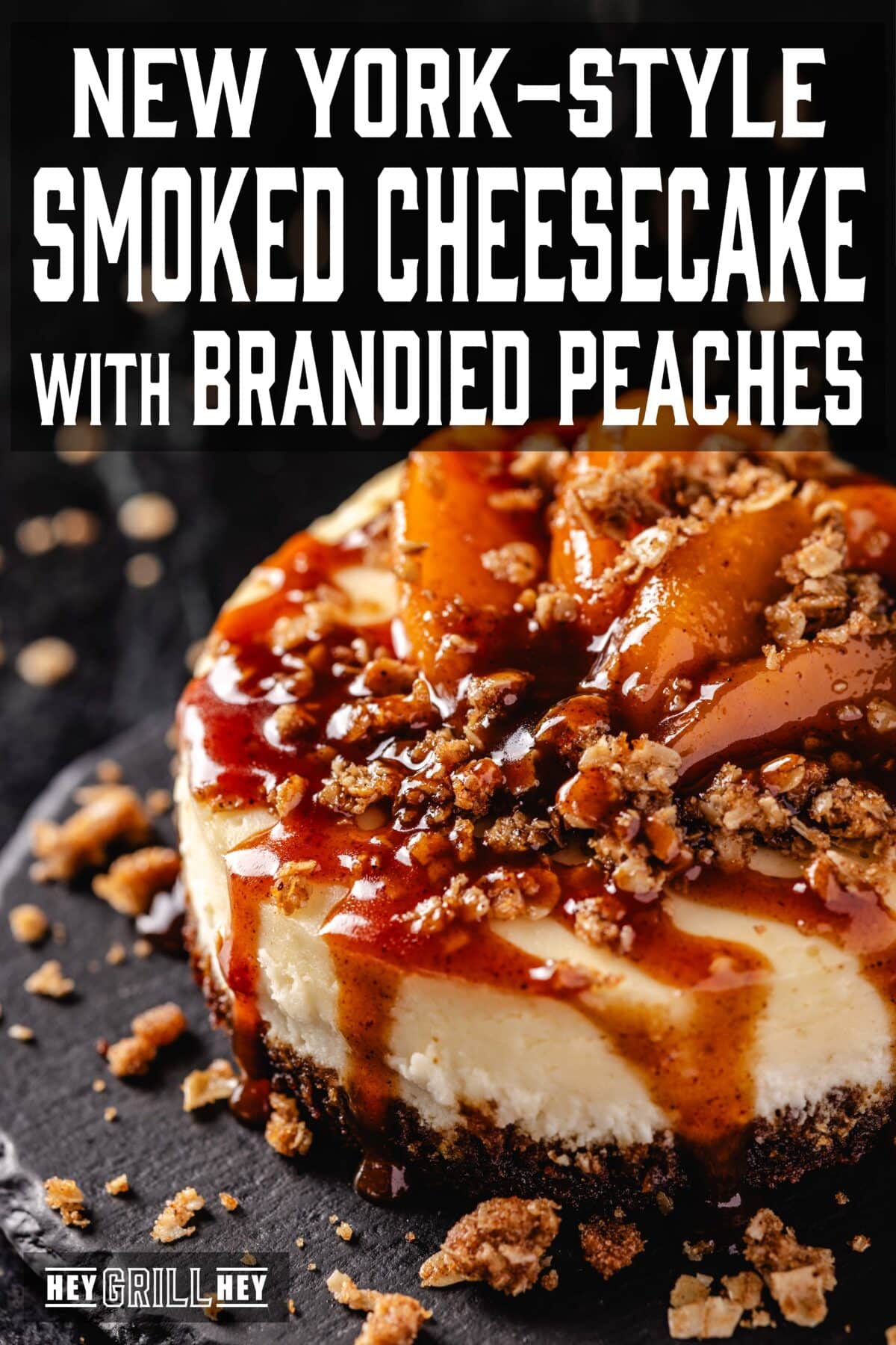 A cheesecake topped with peach slices, caramel sauce, and a graham cracker crumble. The text overlay reads "New York-style Smoked Cheesecake with Brandied Peaches" at the top, and "Hey Grill Hey" at the bottom.