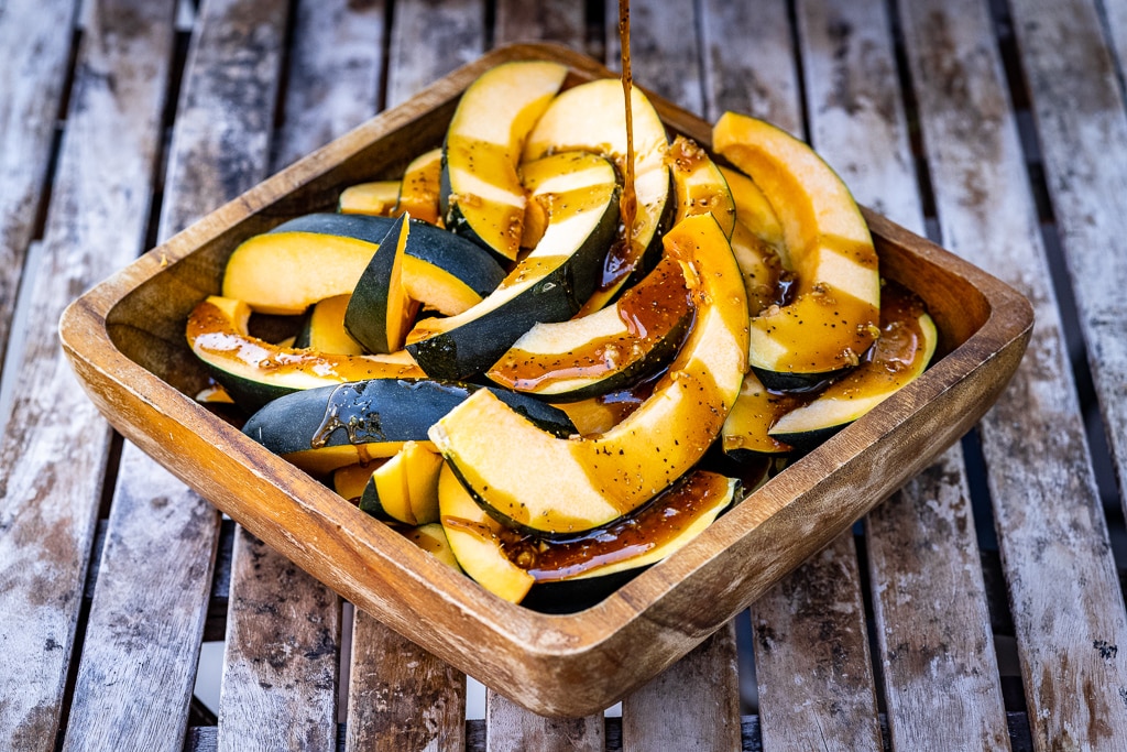 Acorn squash spears being drizzled with a butter and sugar mixture.
