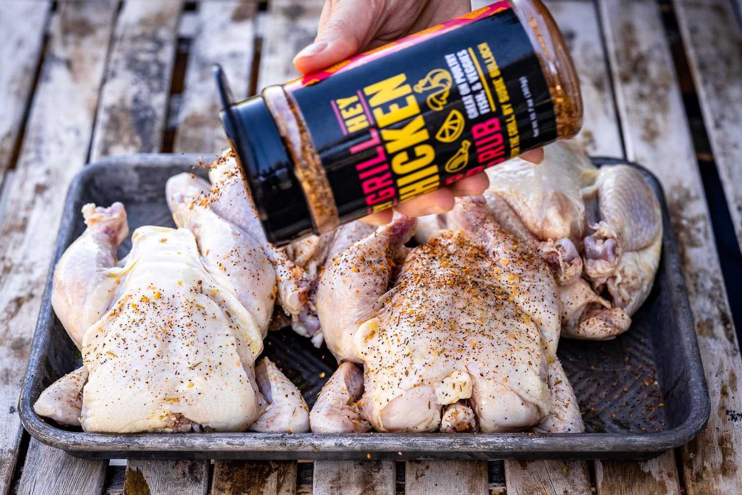 Hey Grill Hey Chicken Seasoning being sprinkled on four cornish hens.