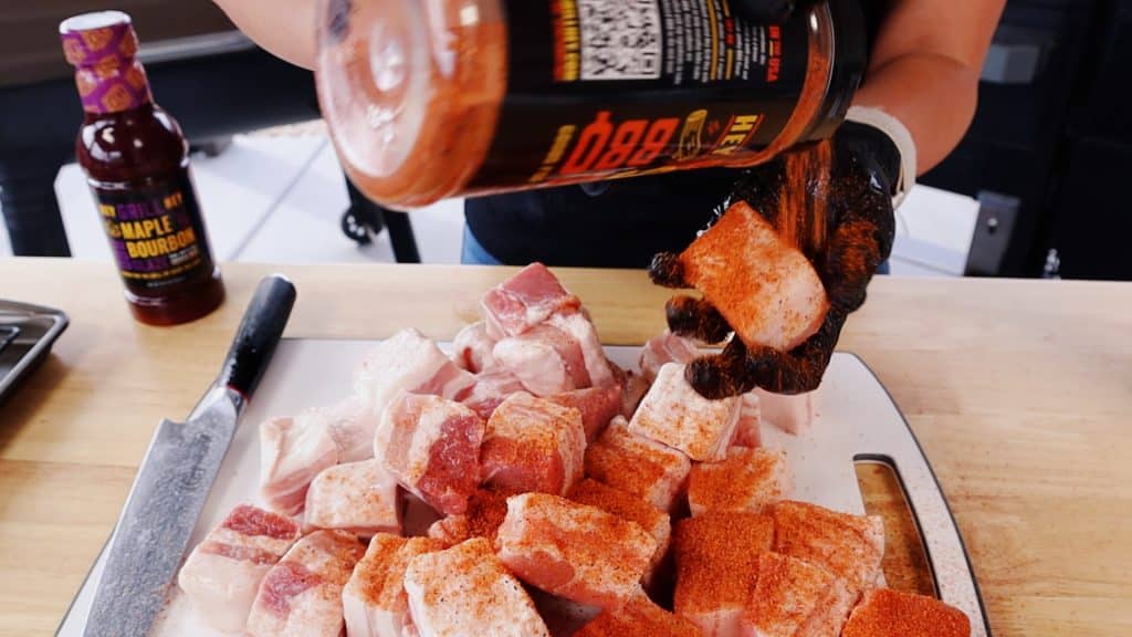 Hey Grill Hey Sweet Rub being sprinkled on pork belly cubes.