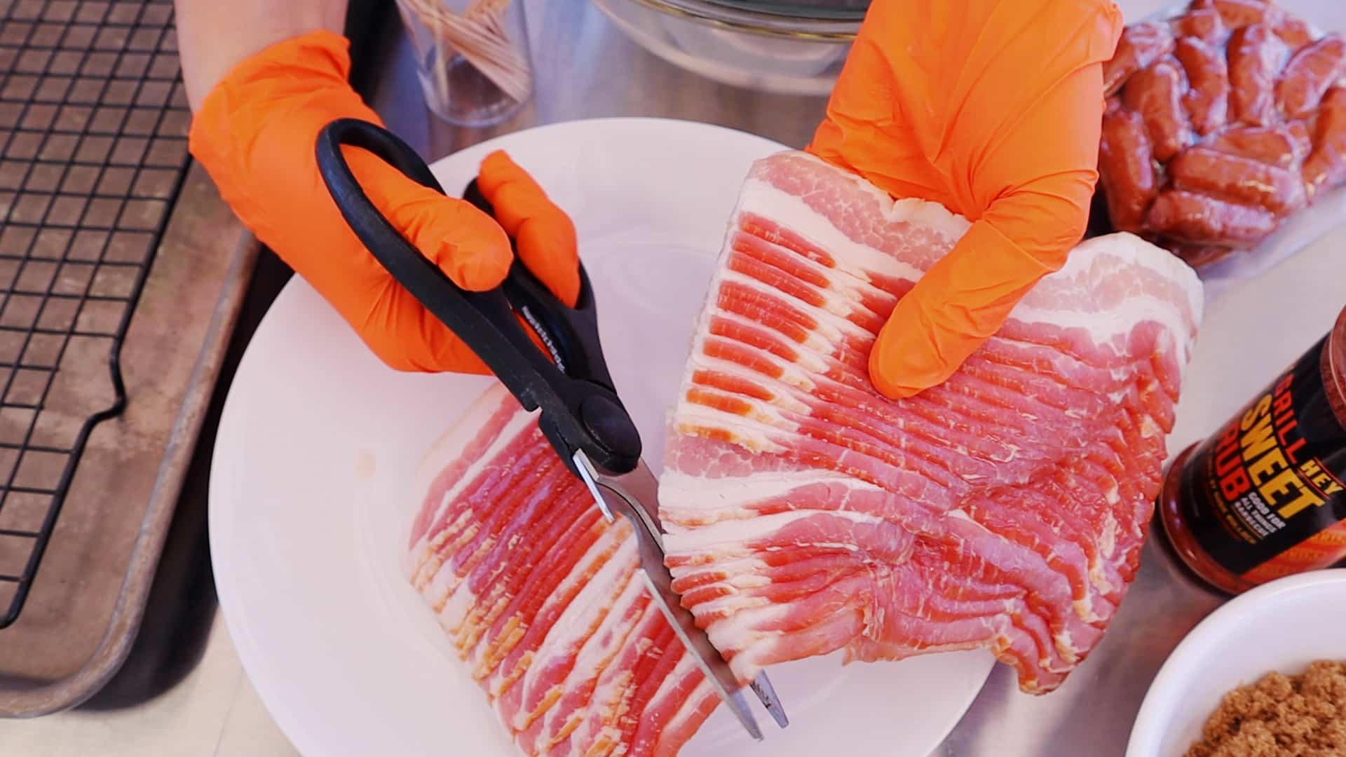 Bacon being cut into thirds with kitchen shears.