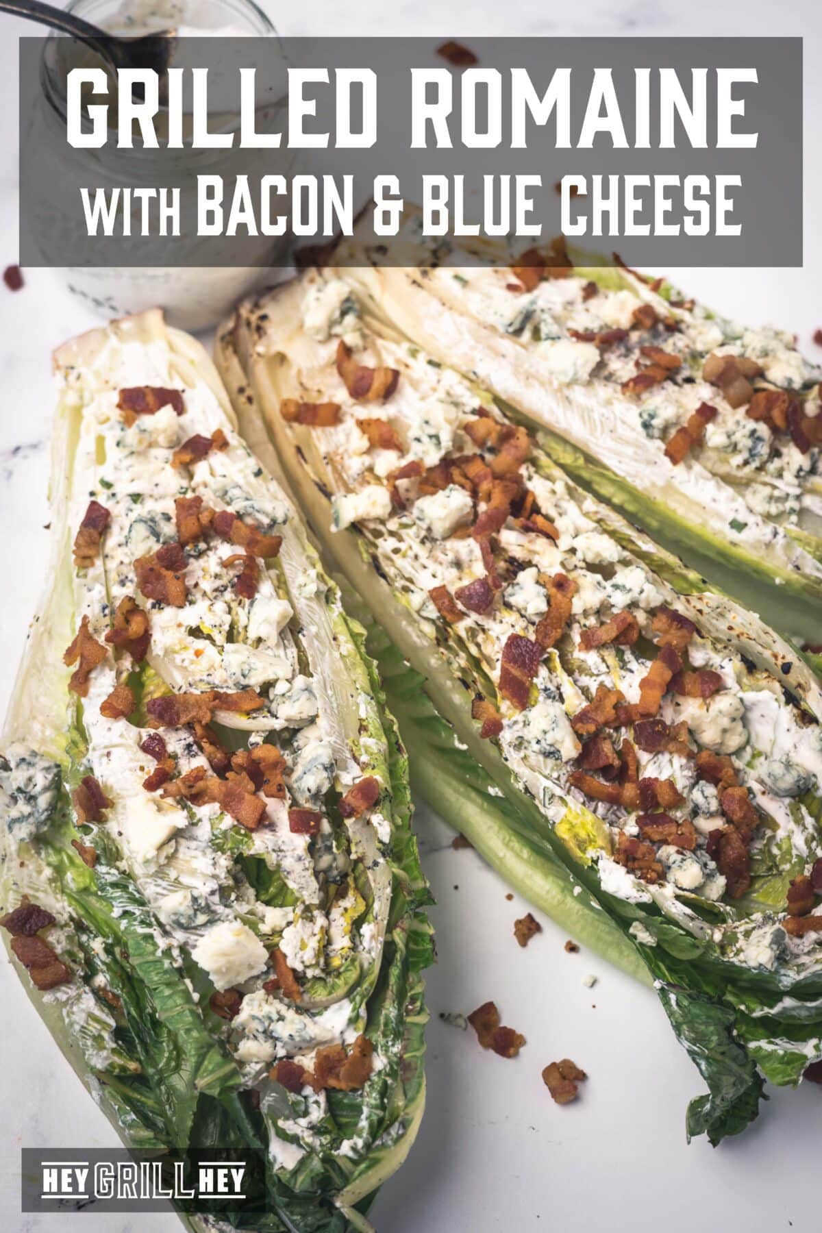 Three romaine stalks covered in dressing and bacon crumbles. The text overlay reads "Grilled Romaine with Bacon and Blue Cheese" at the top, and "Hey Grill Hey" at the bottom.