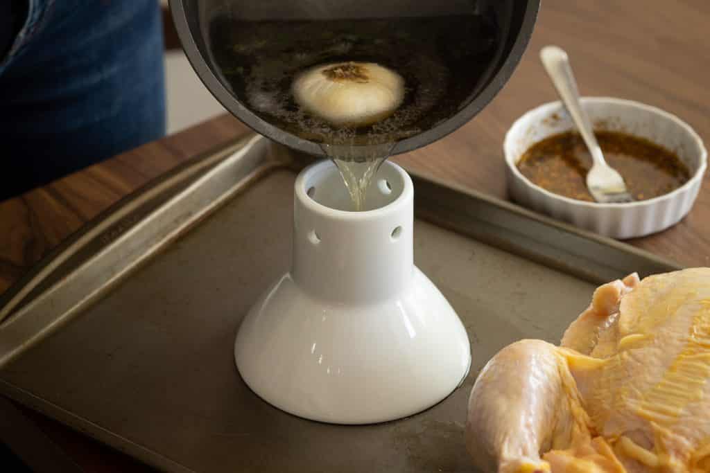 Boiled beer pouring into a beer can chicken roaster.