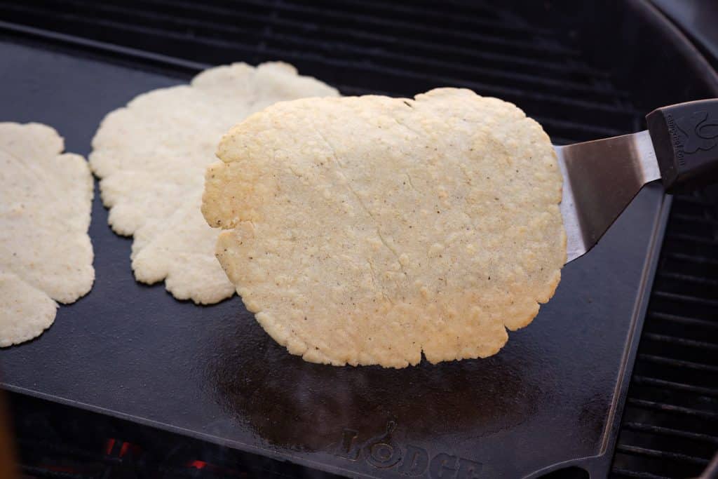 Rolled corn tortillas on a oiled skillet.