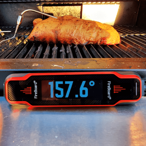 Fireboard Spark thermometer probed into a piece of meat on the grill.