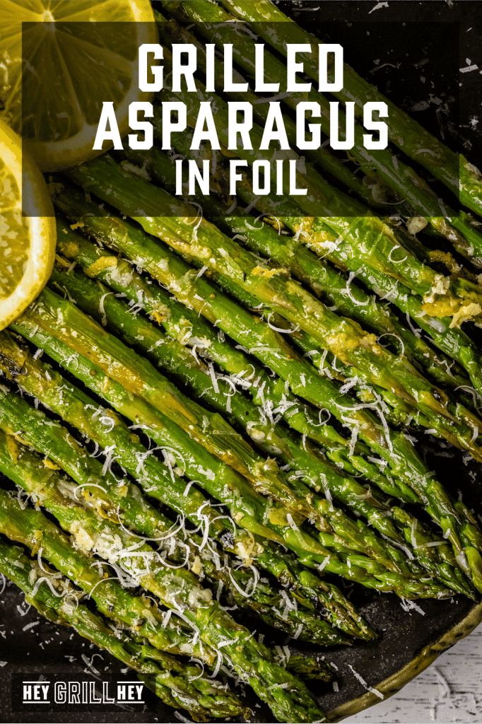 Stacked grilled asparagus topped with shredded parmesan cheese with text overlay - Grilled Asparagus in Foil.