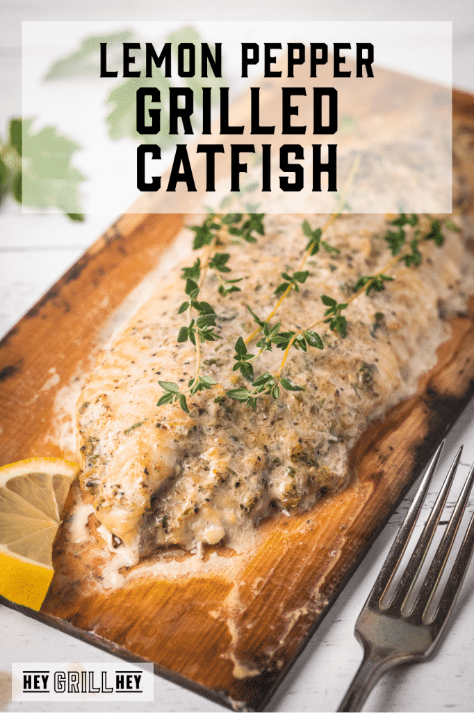 Grilled catfish filet on a cedar plank with text overlay - Lemon Pepper Grilled Catfish.
