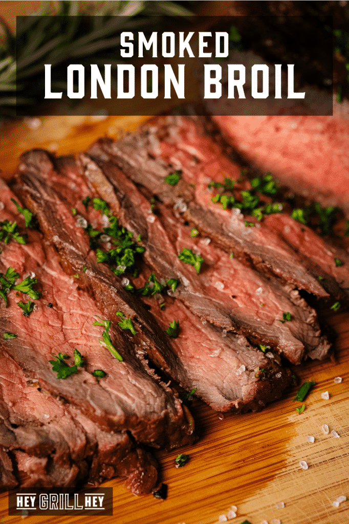 Smoked and sliced London broil on a wooden cutting board with text overlay - Smoked London Broil.
