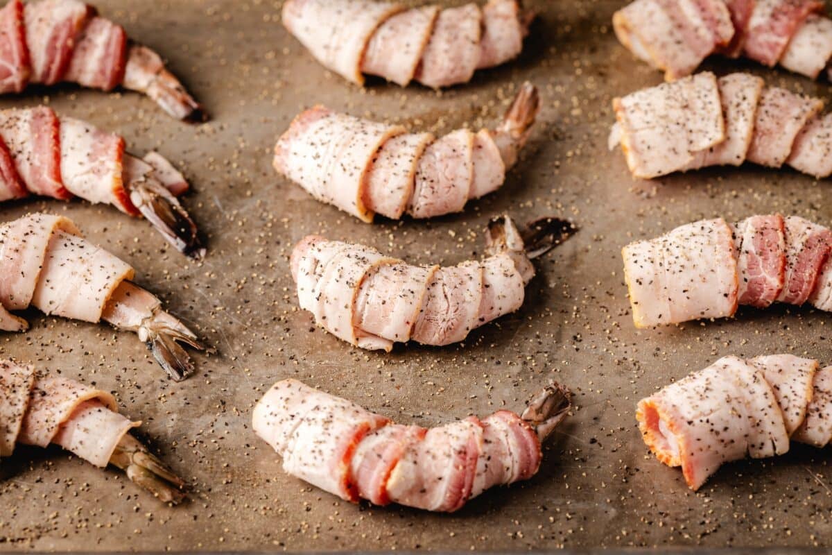 A baking sheet full raw, seasoned shrimp.