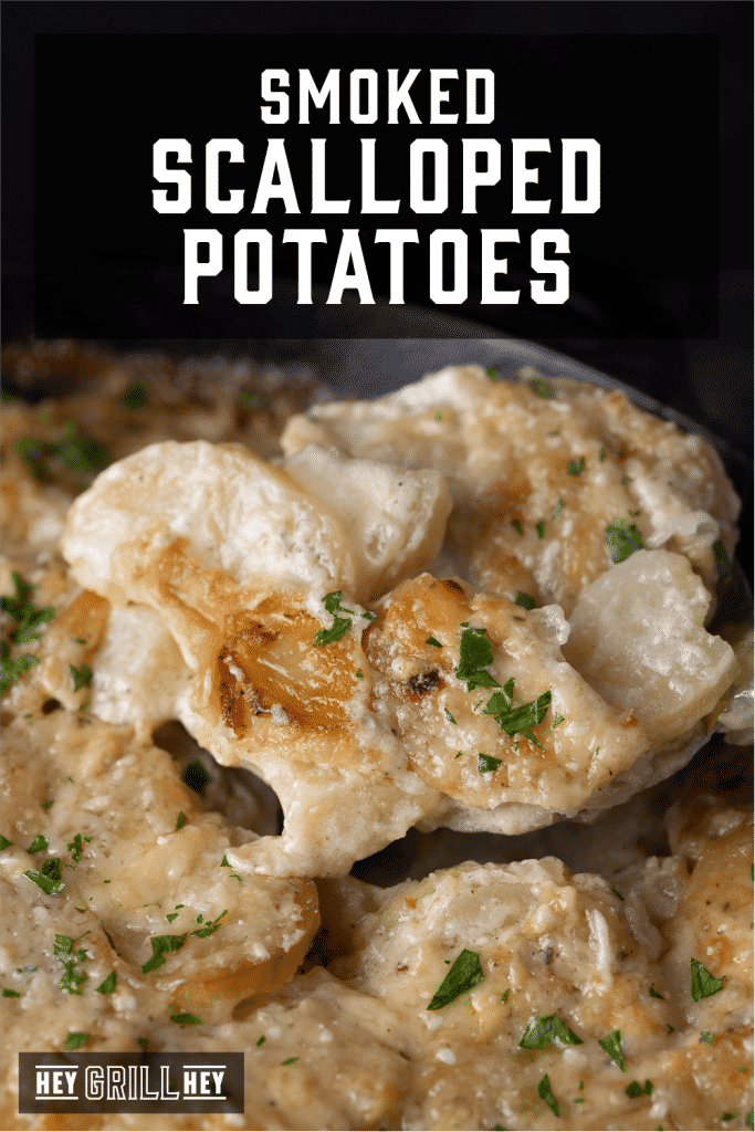 Smoked scalloped potatoes being scooped out of a cast iron skillet with text overlay - Smoked Scalloped Potatoes.