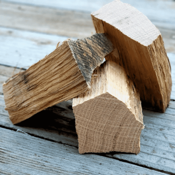Three chunks of wood piled on a deck.
