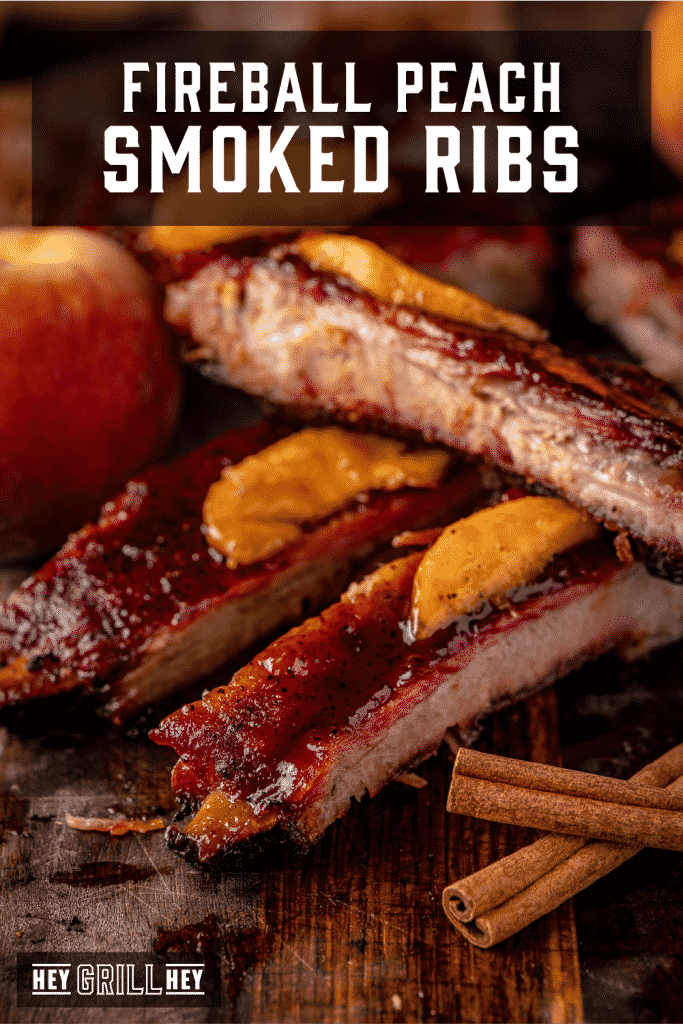 Fireball smoked ribs stacked on a cutting board with text overlay - Fireball Peach Smoked Ribs.