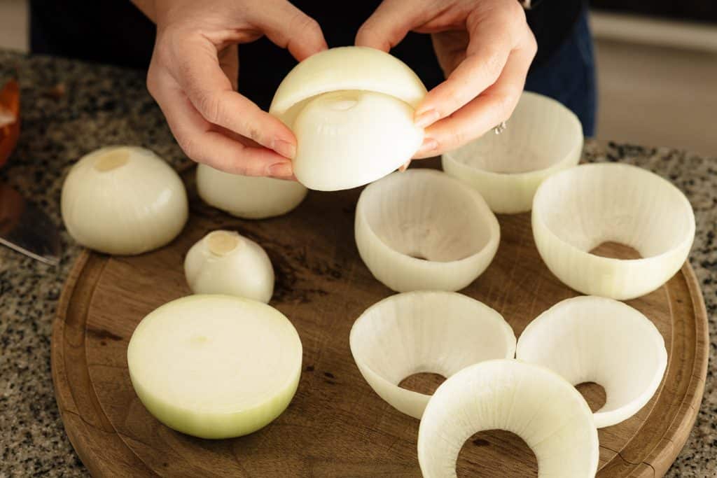 Sliced onions being separated into large pieces.