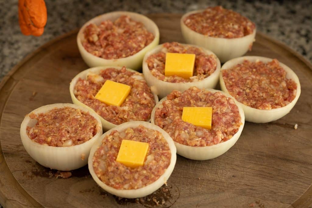 Onion halves stuffed with sausage and cubes of cheese.