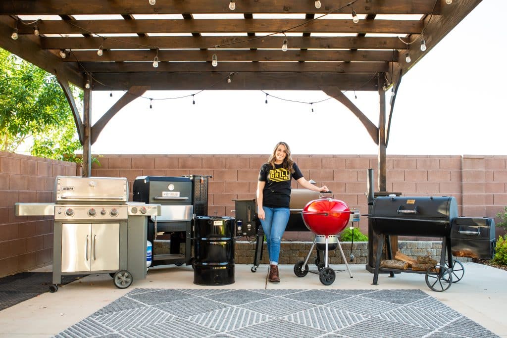 Susie standing in front of a collection of grills.