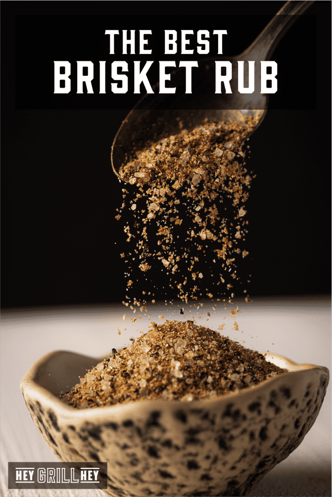 Brisket rub pouring into a bowl out of a spoon with text overlay - The Best Brisket Rub.