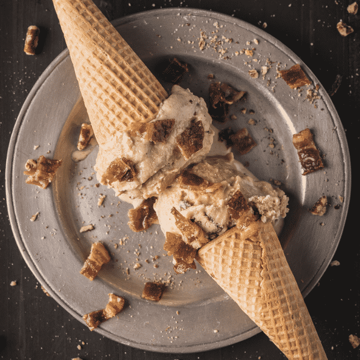 Two cones of maple smoked ice cream on a plate.