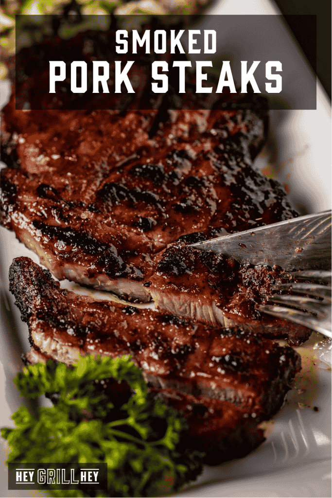 Sliced smoked pork steaks on a white plate with text overlay - Smoked Pork Steaks.