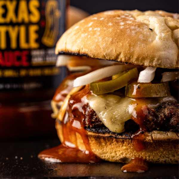 Smoked brisket burger next to a bottle of Texas Style BBQ Sauce.