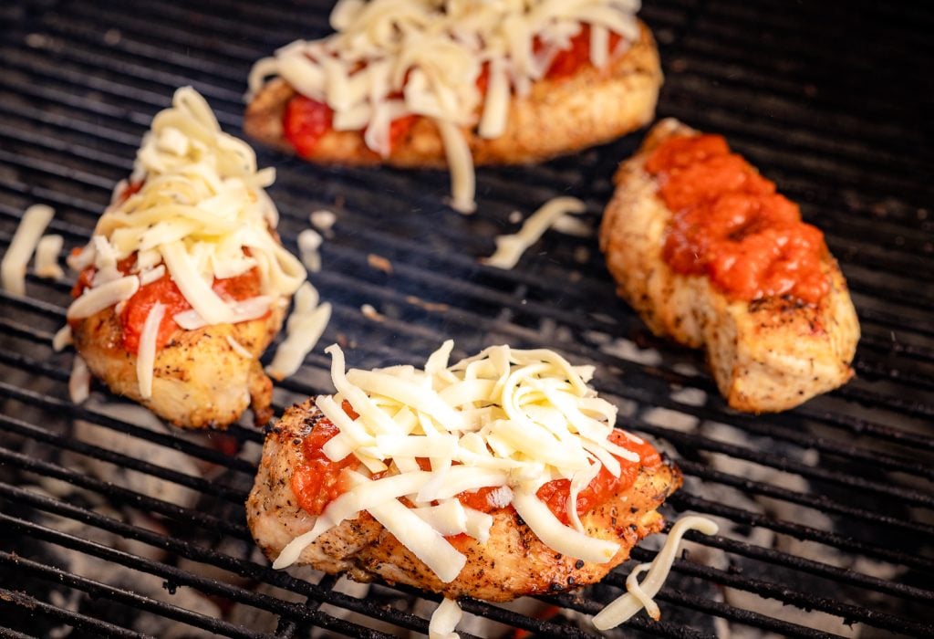 Marinara and shredded cheese on grilled chicken breasts.