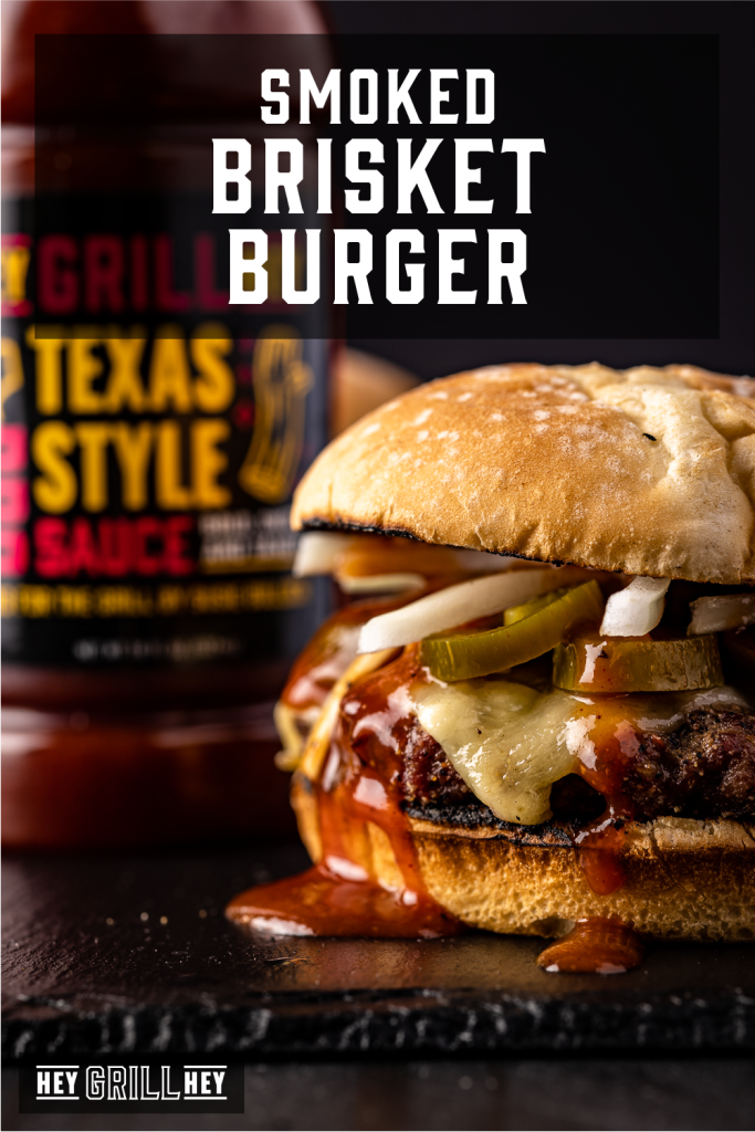 Smoked brisket burger next to a bottle of Texas Style BBQ Sauce with text overlay - Smoked Brisket Burger.