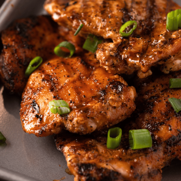 Grilled Buffalo chicken thighs on a baking dish.