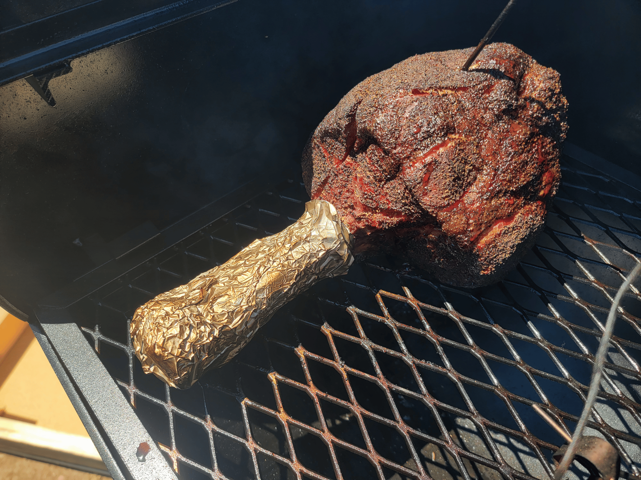 a frenched beef shin on the grill grate