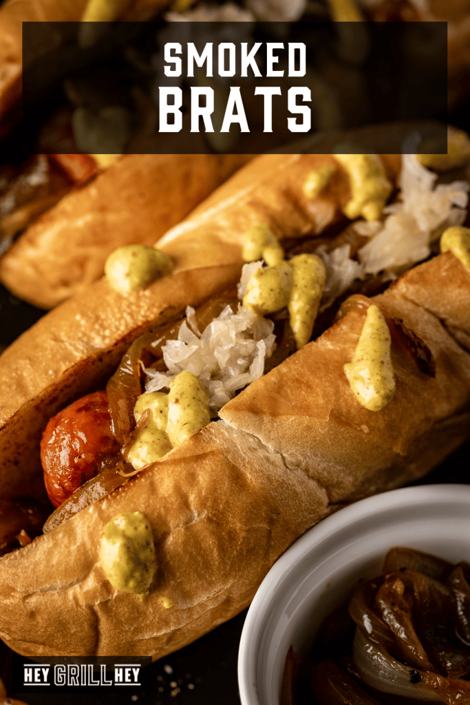 Smoked brats topped with beer onions and deli mustard with text overlay - Smoked Brats.