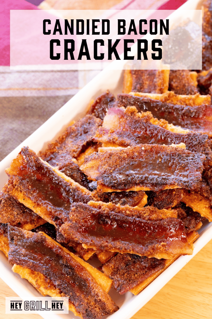 Pile of candied bacon covered crackers on a serving dish with text overlay - Candied Bacon Crackers.
