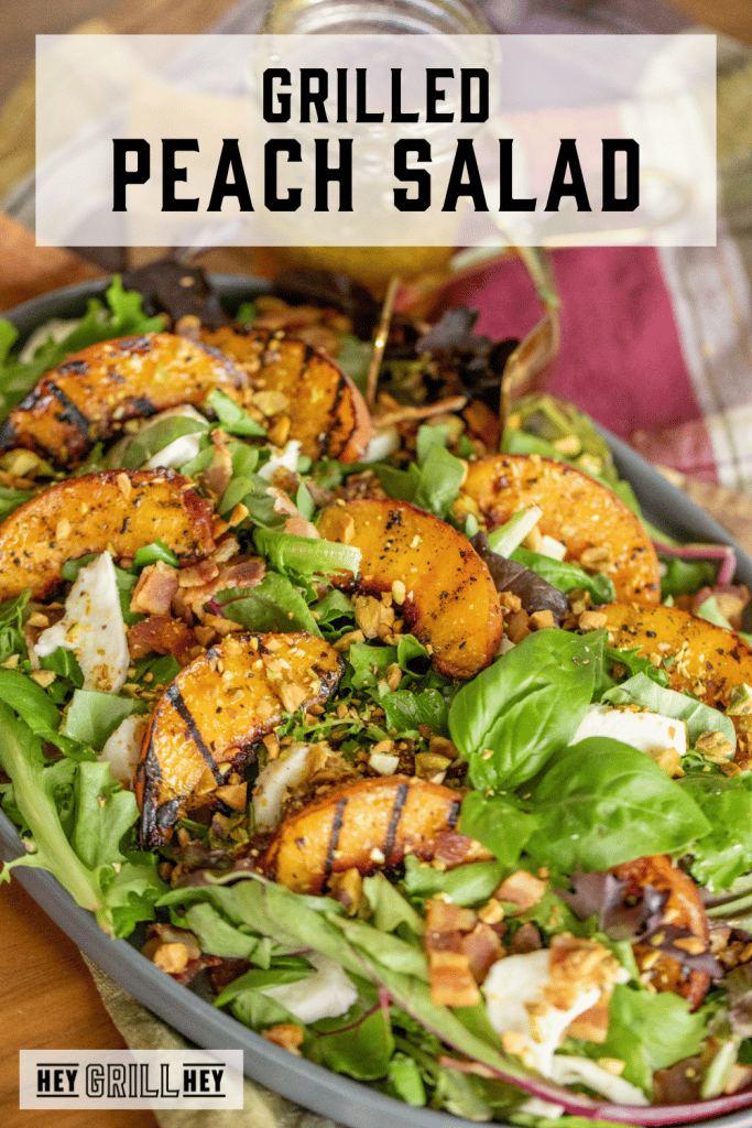 Grilled peach salad in a large serving dish with text overlay - Grilled Peach Salad.