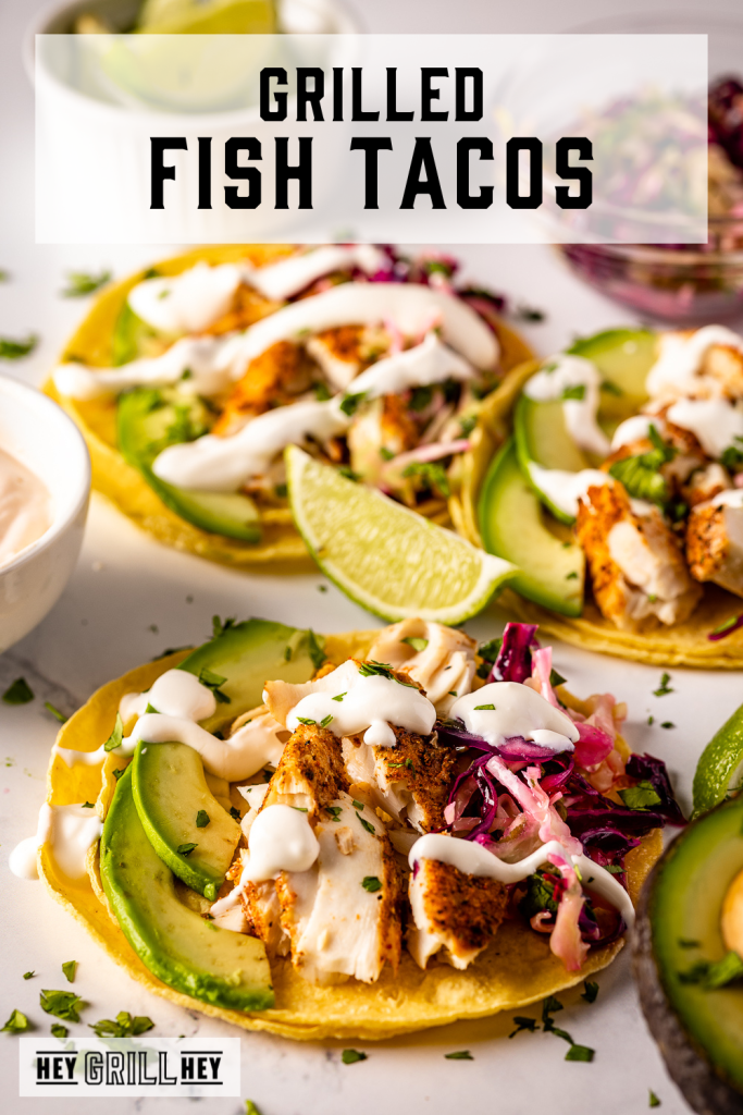 Grilled fish tacos on a white serving dish with text overlay - Grilled Fish Tacos.