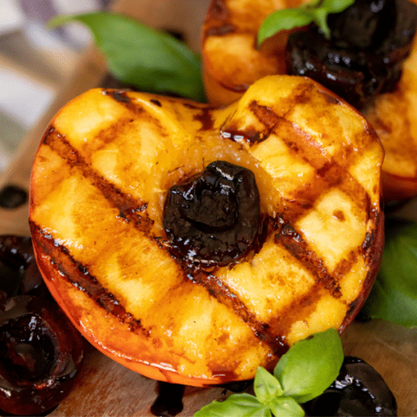 Grilled peaches on a serving dish.