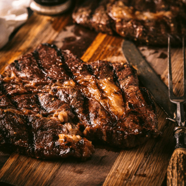 Grilled chuck steak on a wooden cutting board.