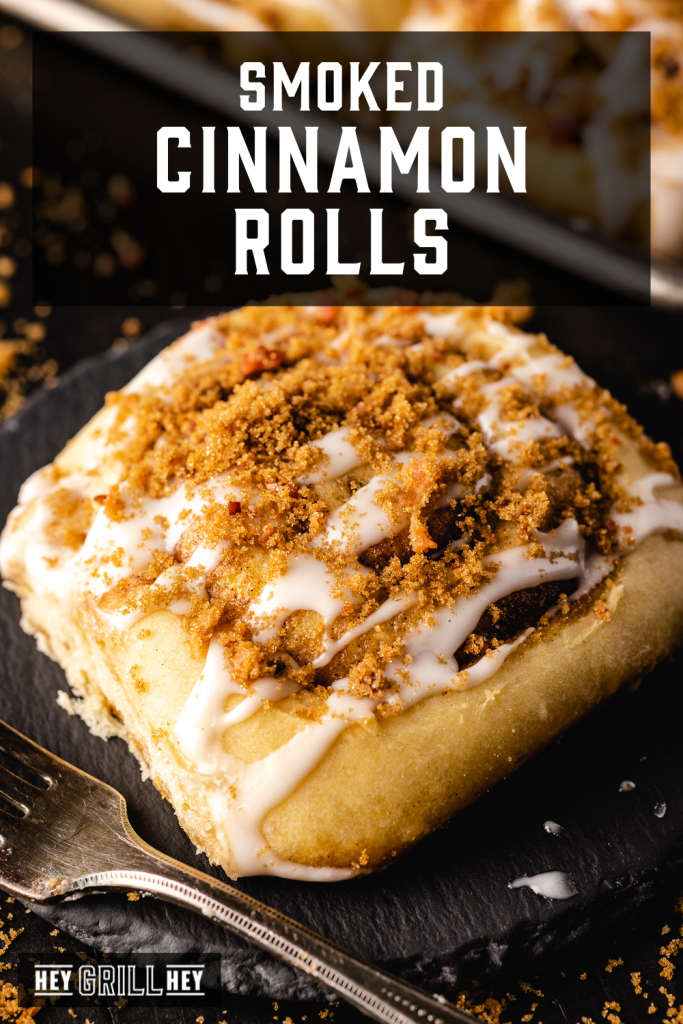 Smoked cinnamon roll on a serving plate with text overlay - Smoked Cinnamon Rolls.