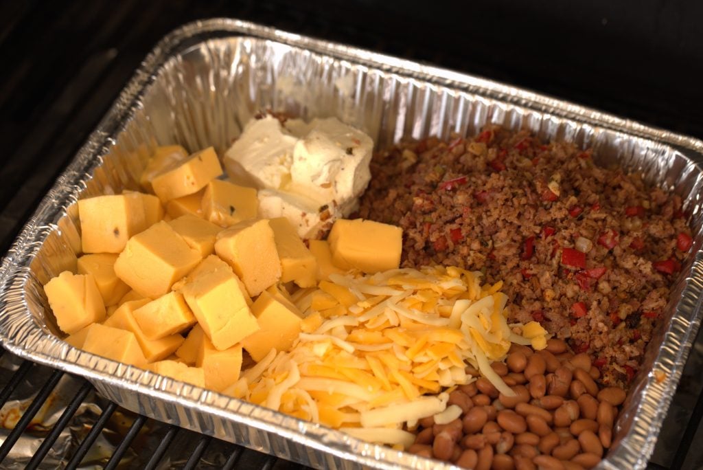 Cheese, beans, and meat in a disposable baking pan.