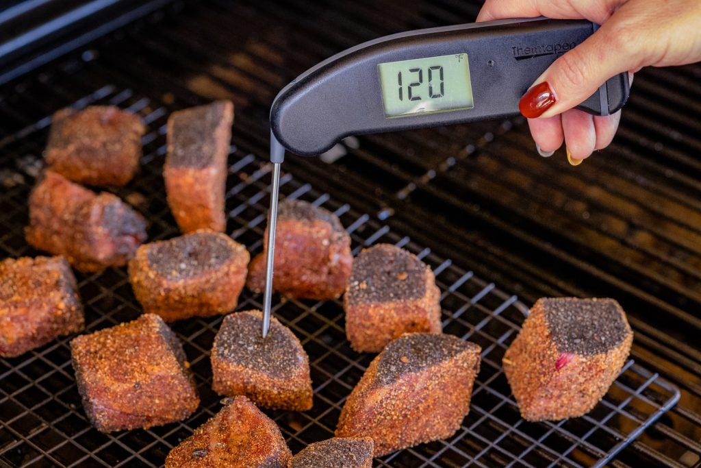 Steak bites on the smoker reading a temperature of 120 degrees F.