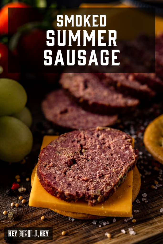 Slice of smoked summer sausage on cheese and crackers with text overlay - Smoked Summer Sausage.