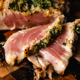 Sliced grilled ahi tuna steaks on a wooden cutting board.