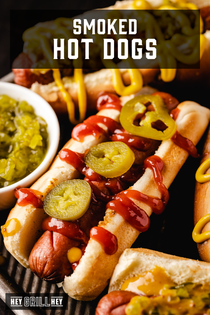 Smoked hot dogs drizzled with ketchup and topped with sliced jalapenos with text overlay - Smoked Hot Dogs