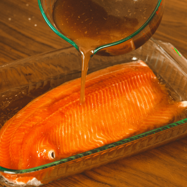 Salmon brine being poured over a large salmon filet.