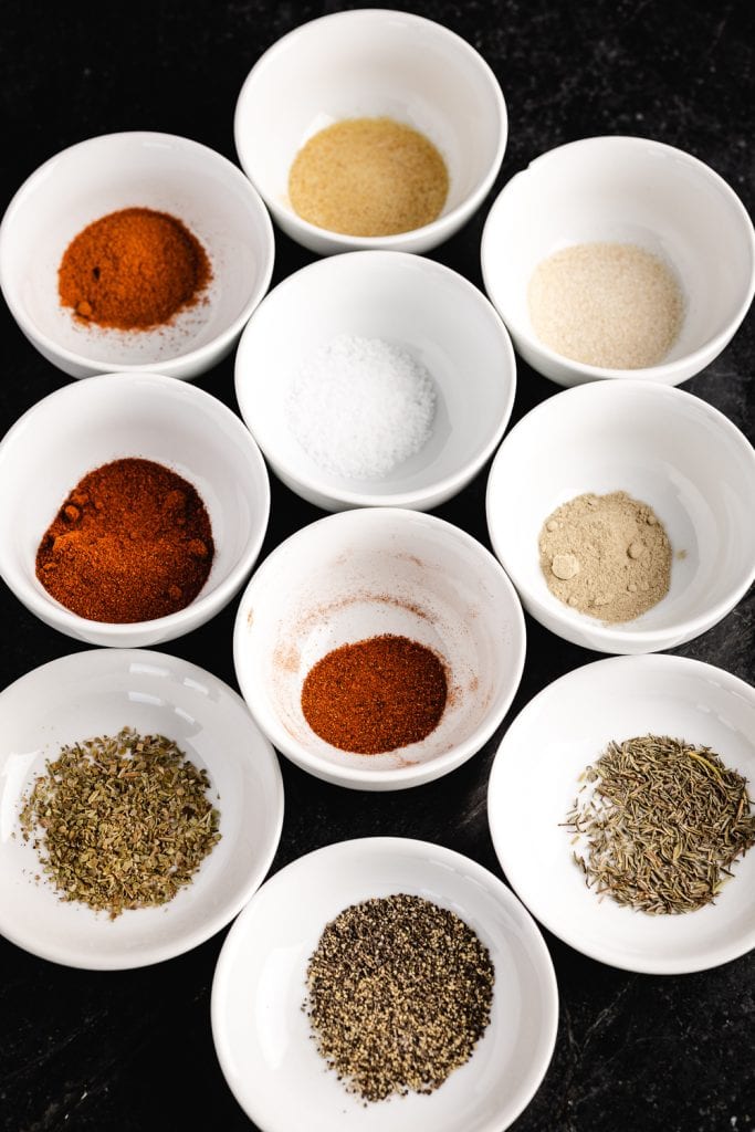 Ingredients for blackened seasoning in small white bowls.