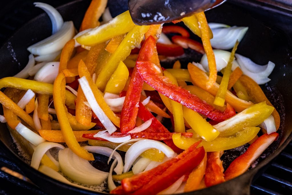 Sliced bell peppers in a skillet.